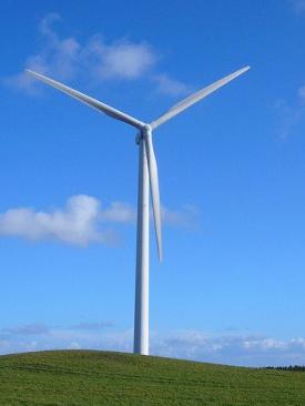 wind turbine grassy hill blue sky