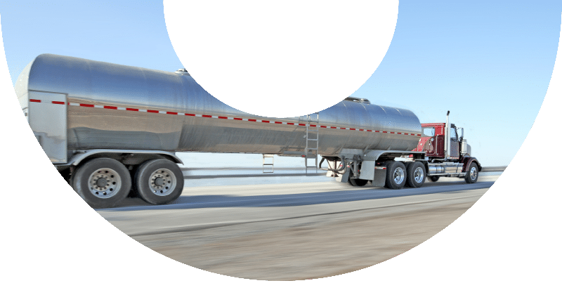 red fuel truck with red and white stripe on tank in motion