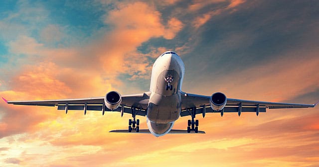 airplane climbing at dusk pink orange sky