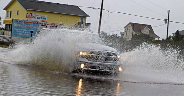 silver truck driving through floaded road