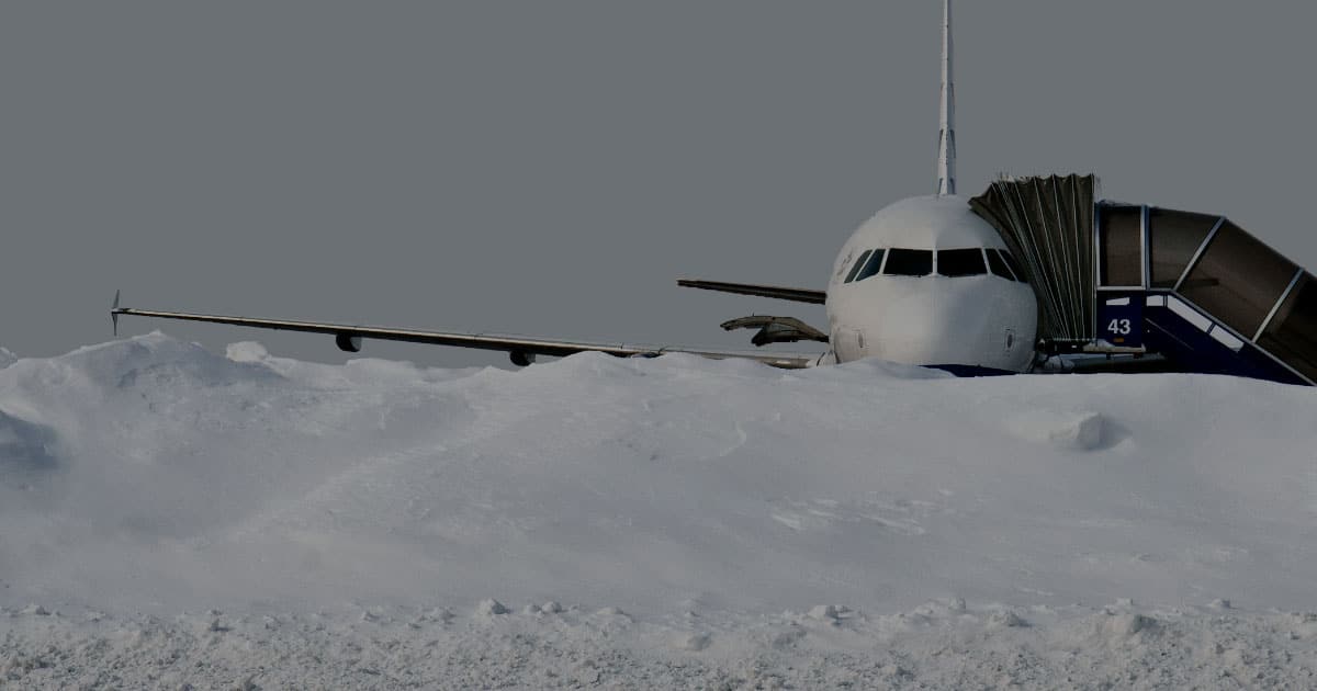 RunwayMaster airplane covered up to wings in snow