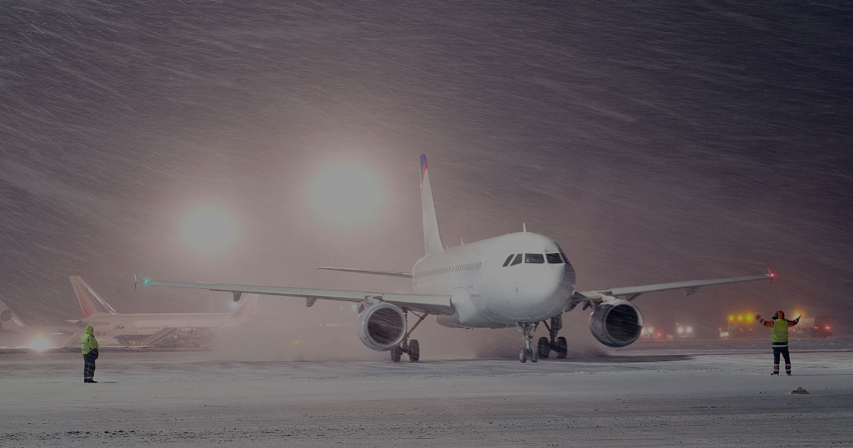 RunwayMaster commercial airplane being directed on runway heavy blowing snow