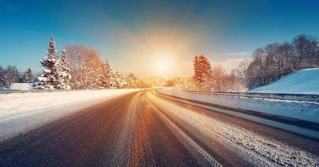 Sun rising over a plowed road