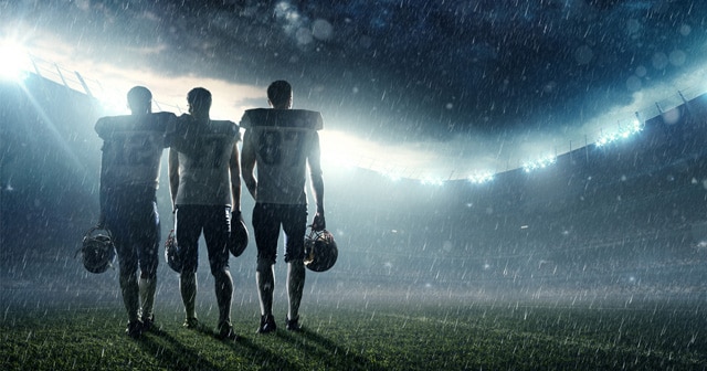 Football players on rainy field