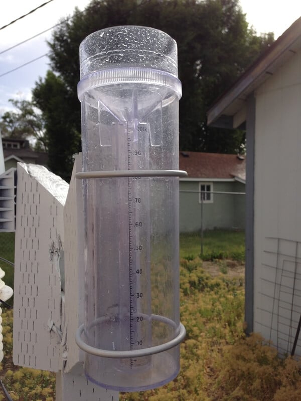 CoCoRaHS rain gauge attached to a fencepost.