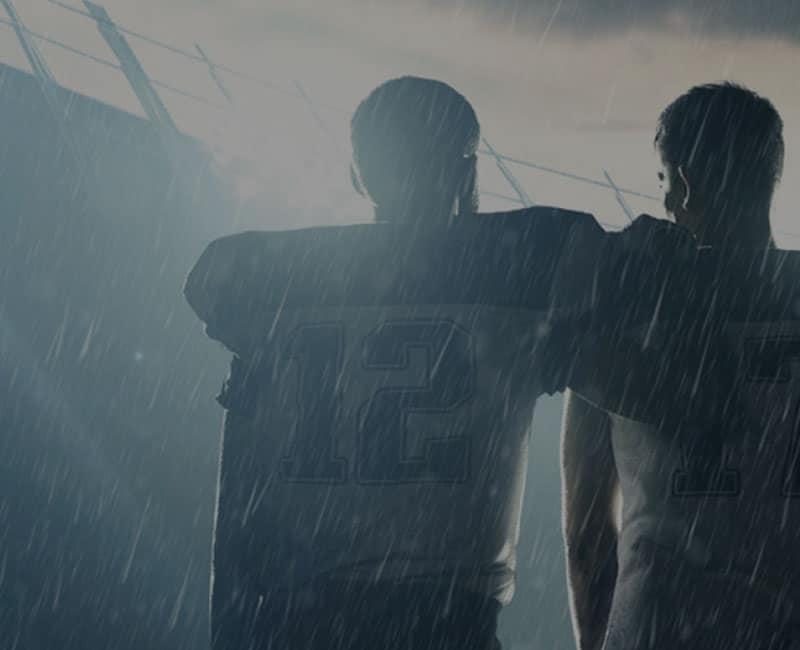 football players in rain at stadium
