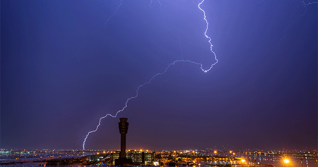 Air traffic control tower with lightning in the sky