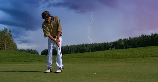 Golfer putting with lightning in background