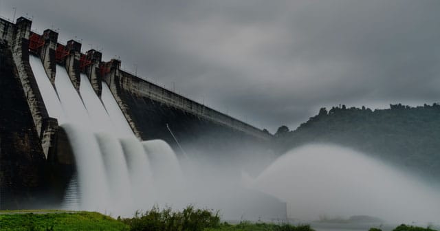 dam water spillway red gates dark sky