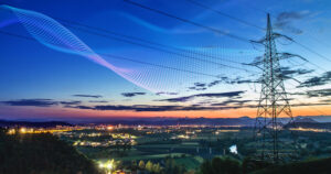 High power electricity pylon above a city skyline