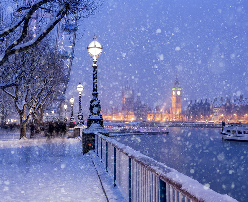 snowy riverside dusk scene with light and skyline