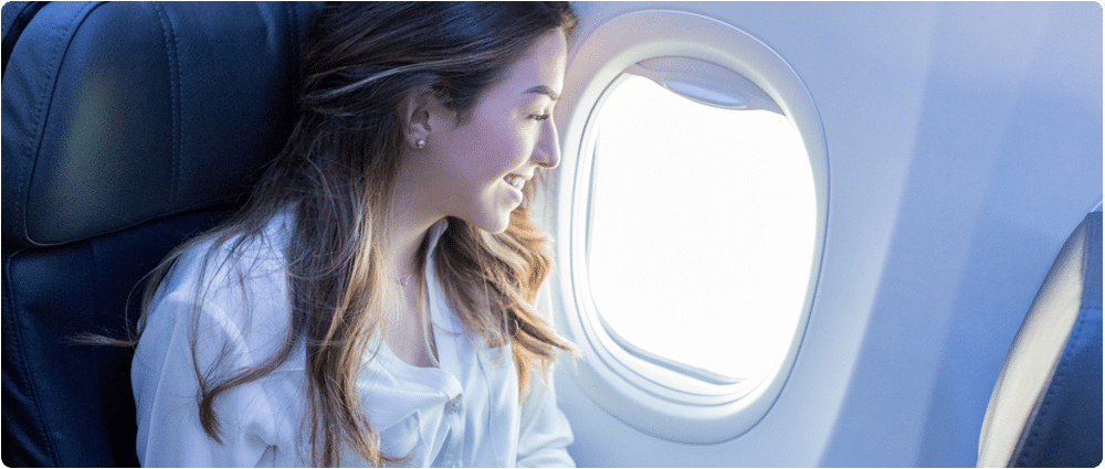woman smiling out of airplane window