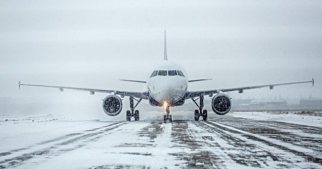 commercial airplane on snowy and icy runway