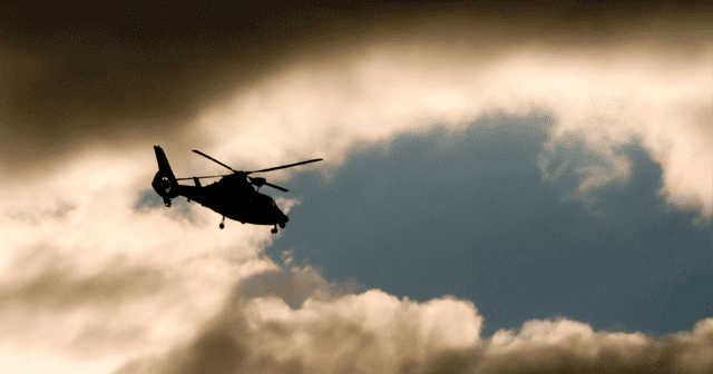 Helicopter silhouette in the clouds