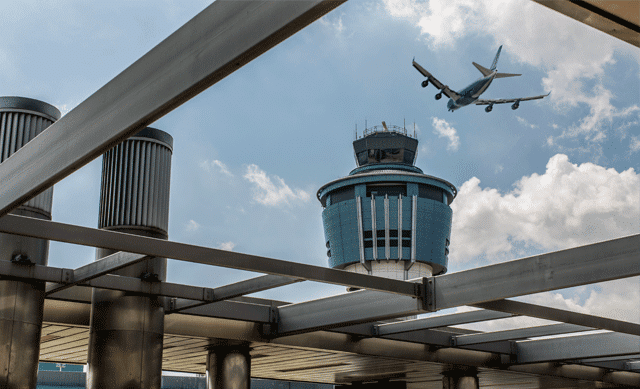 Airplane flying over tower