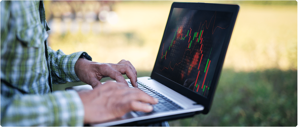 Farmer trading on laptop