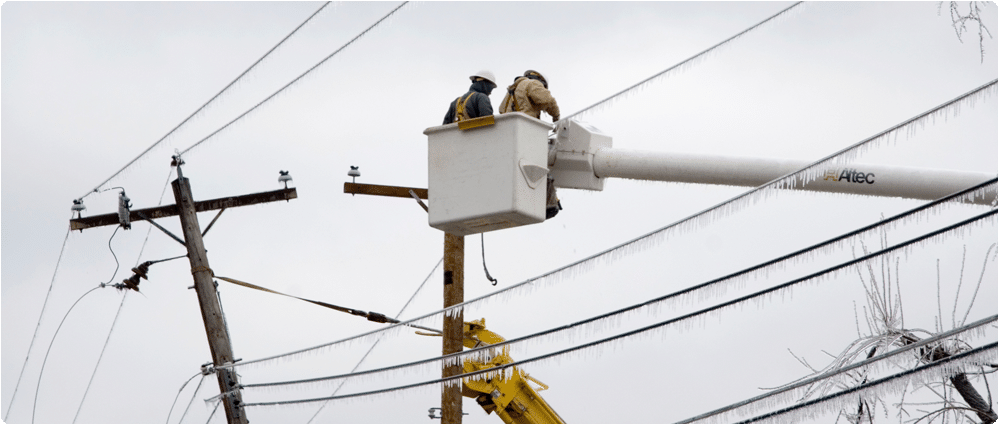 Utility workers on power lines in the winter