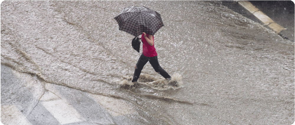 Woman walking with umbrella in heavy rain