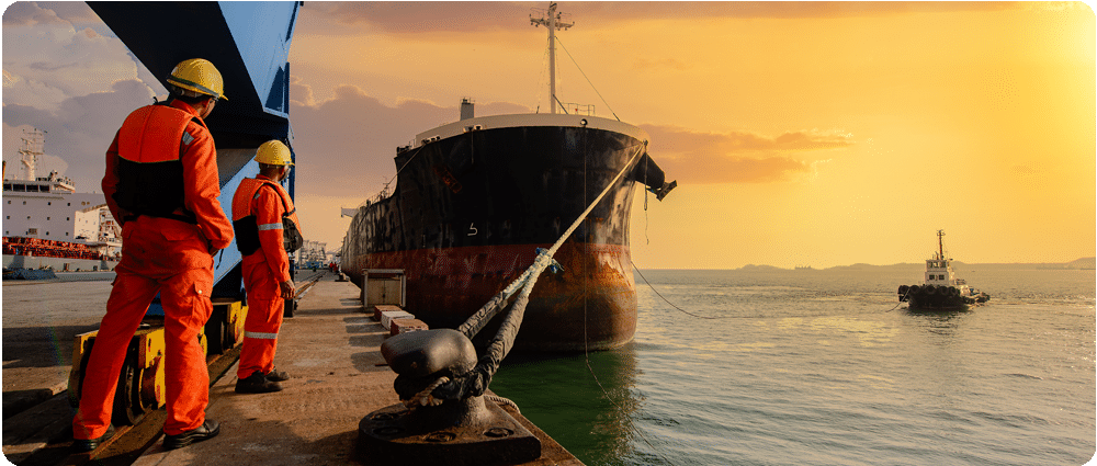 Shipping crew looking at cargo ship