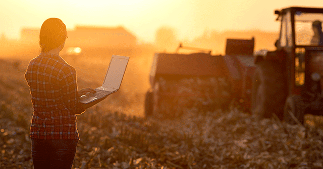 Blog header farmer with laptop in field