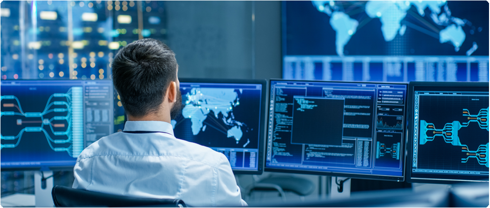Man looking at computer monitors