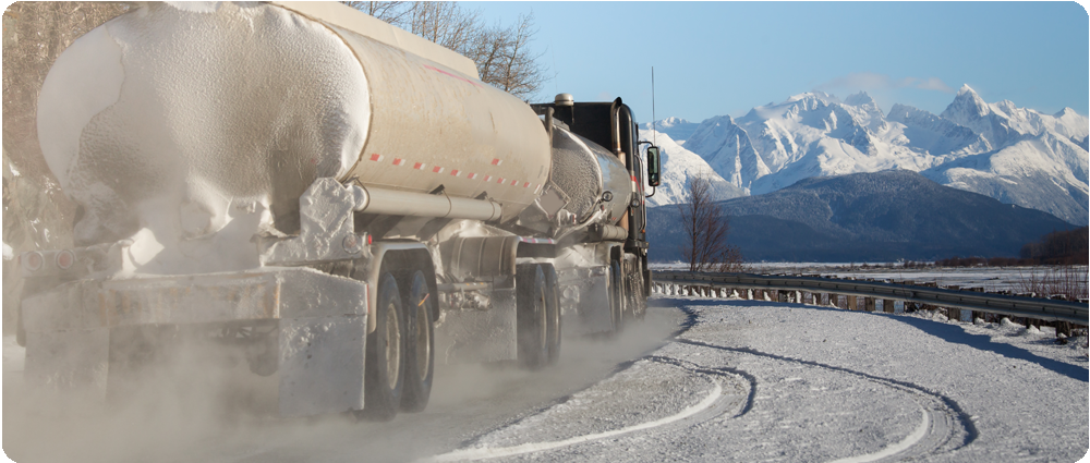 Fuel truck driving on snowy road in the mountains