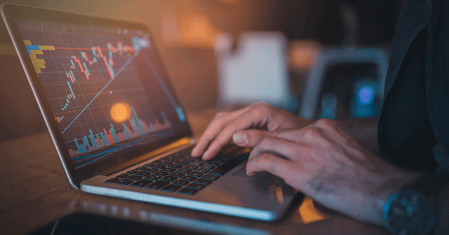 Blog header Hands in laptop with market chart