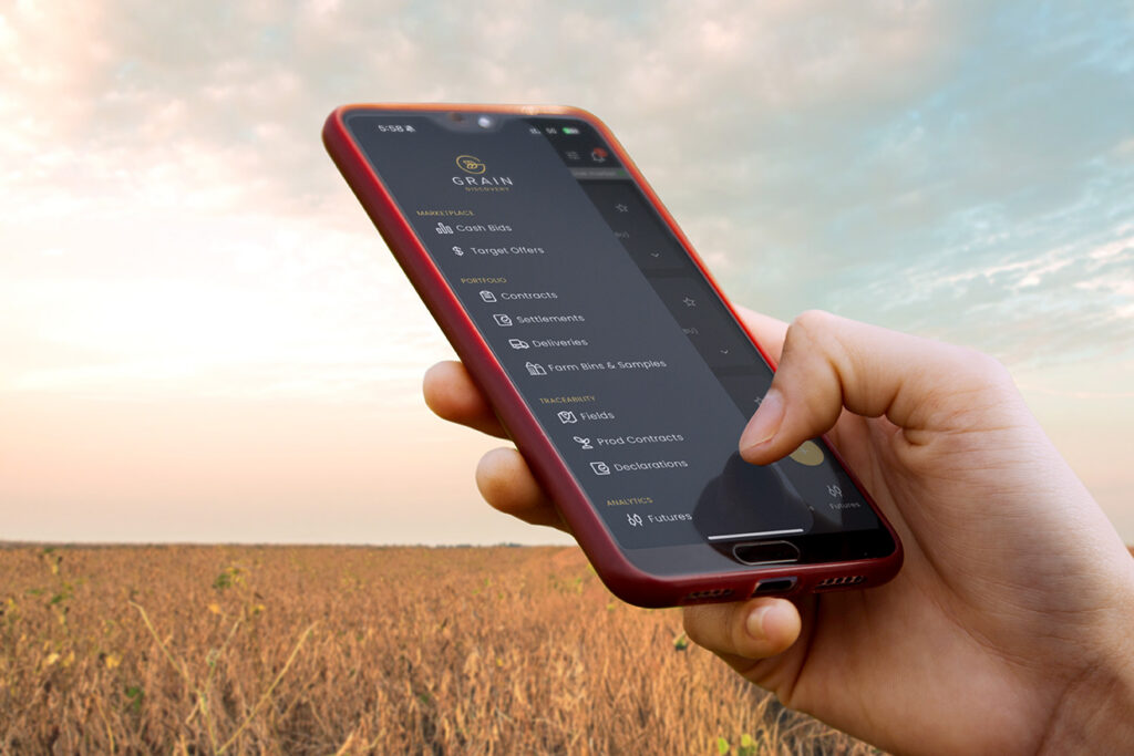 DTN Grain Discovery farmer hand on mobile phone in field